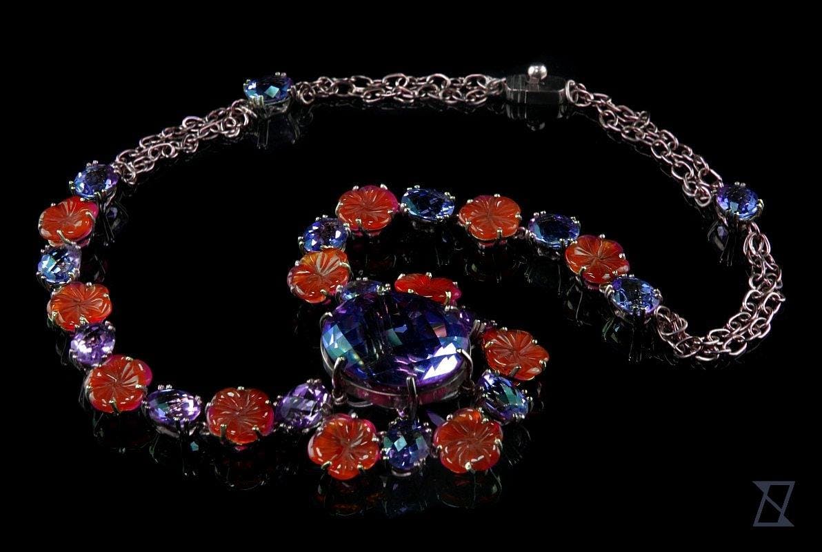 Floral pink palladium gold necklace featuring amethyst and carved carnealin layout.
