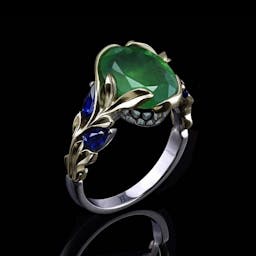 Ring with emerald and sapphires in two tone gold. 
