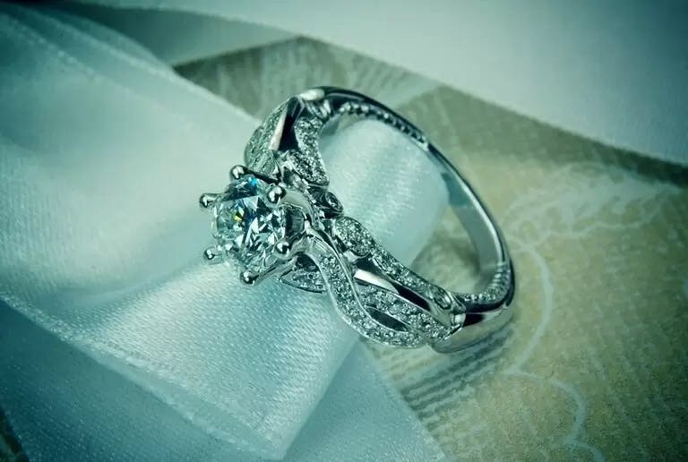 Барочное кольцо с бриллиантом 1 карат и маленькими бриллиантами в золоте 750 пробы.