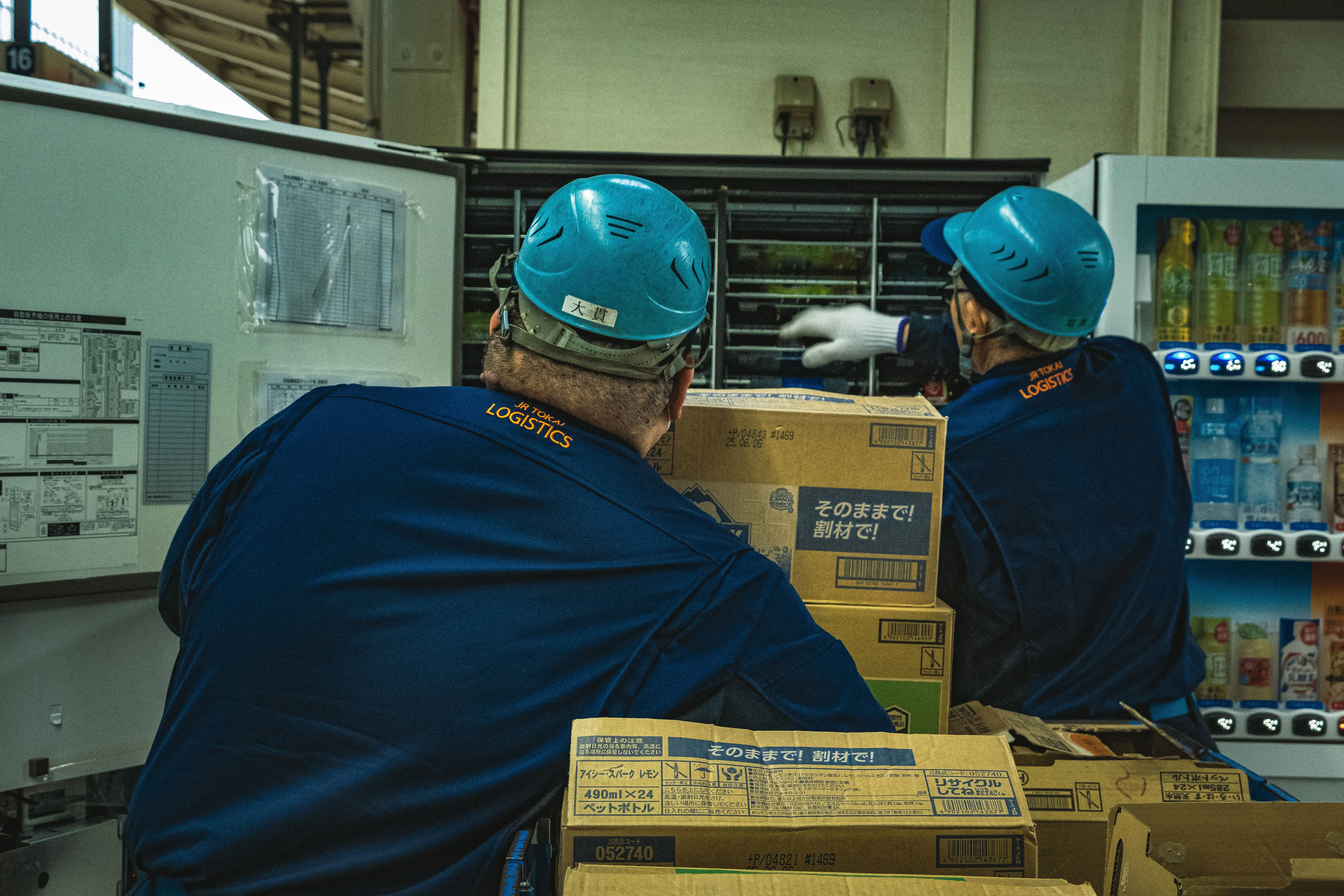 Warehouse workers handling logistics boxes, representing the shipping and logistics due diligence e-commerce businesses need when vetting a new wholesale supplier