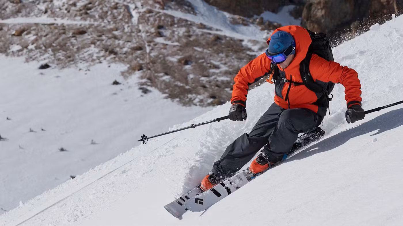 Person in red snow coat skiing down a mountain