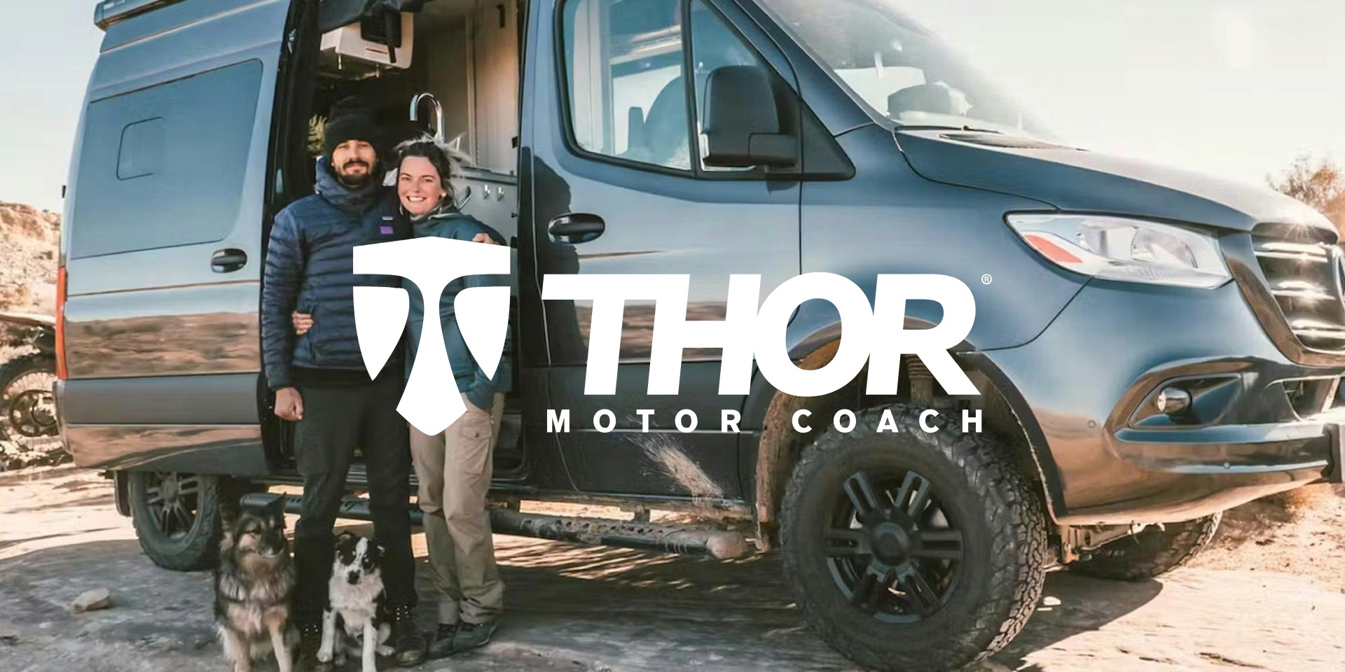 Couple standing next to Sanctuary RV with their dogs