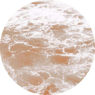 Circle image of the ocean with an orange coloured filter over the top