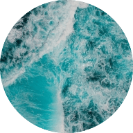 Circle image of the ocean with a teal tinted filter over the top