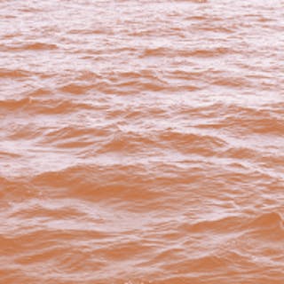 Square image of the ocean with an orange coloured filter over the top