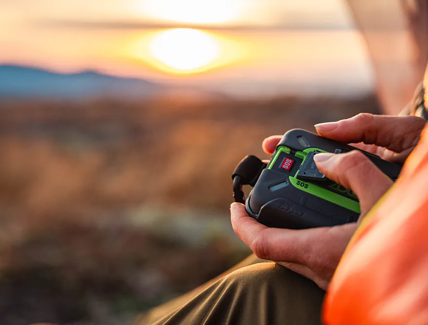 woman hiker holding the ZOLEO 1000 satellite communicator with SOS open