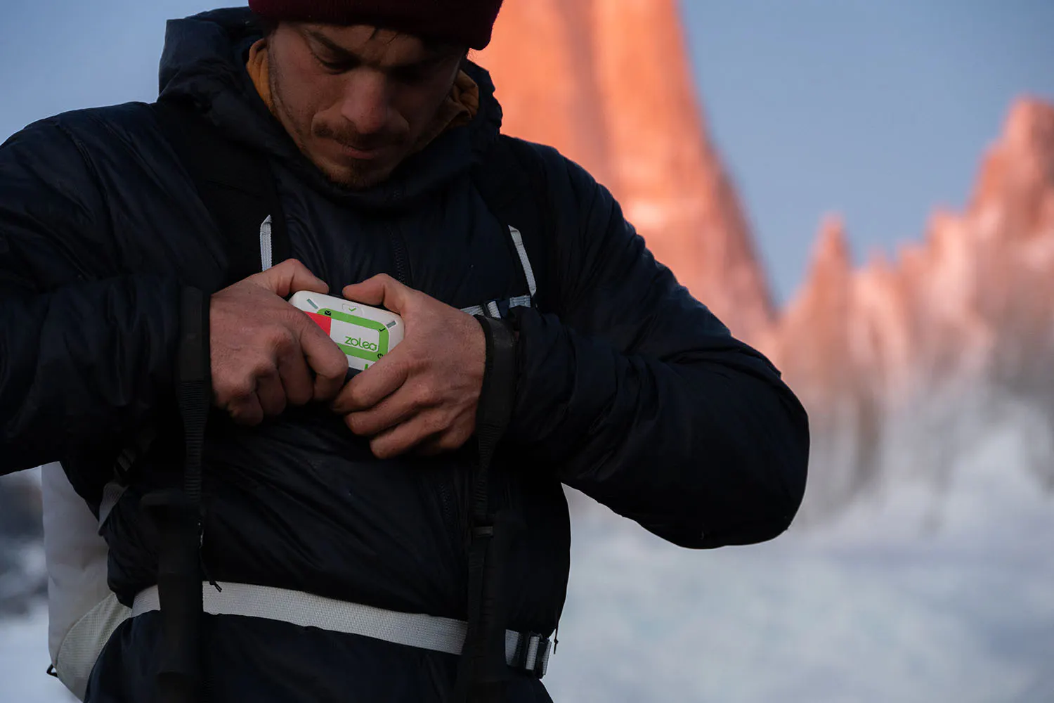 A hiker holding a ZOLEO device