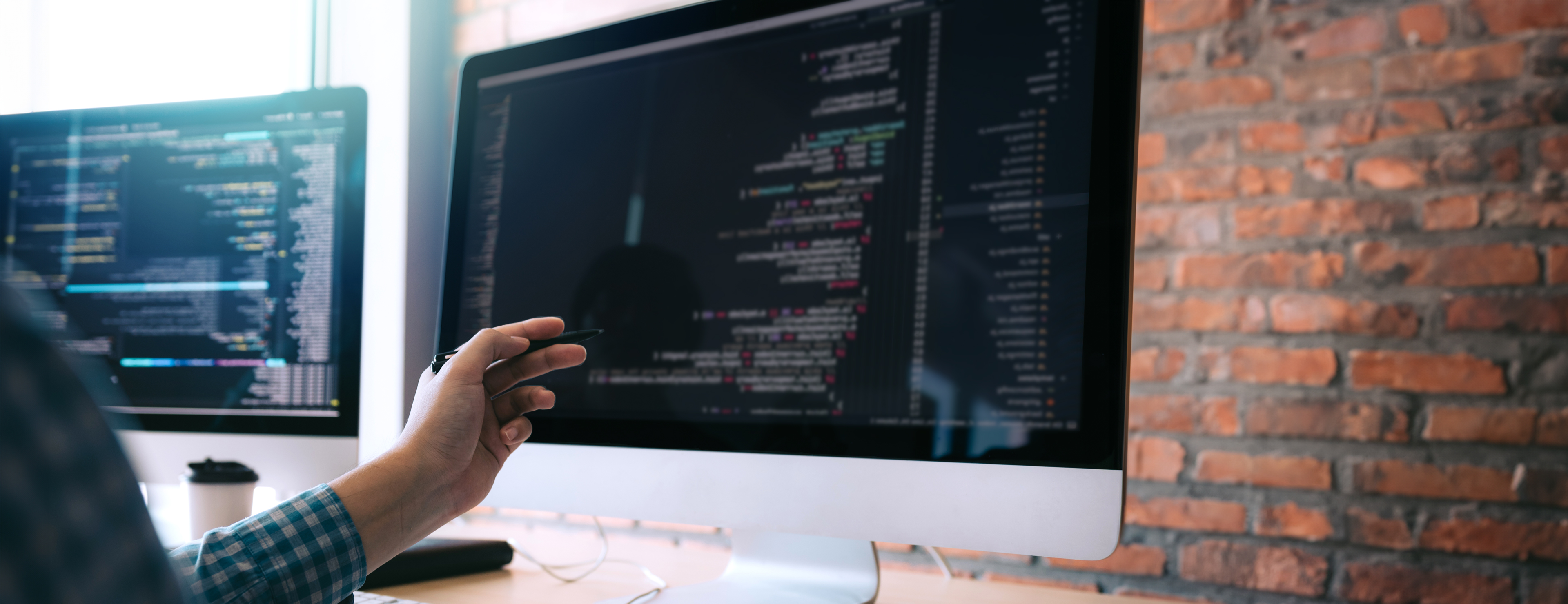 A developer pointing at a computer screen