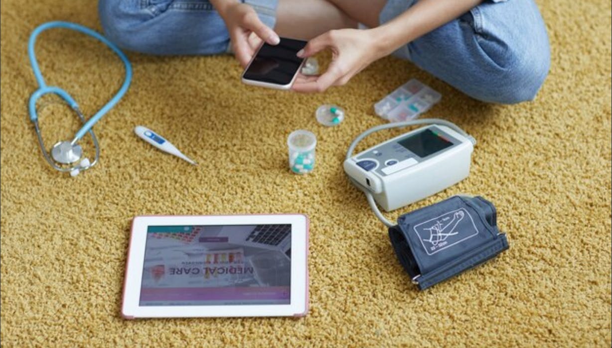 woman-sitting-on-the-floor-with-health-tracking-tools