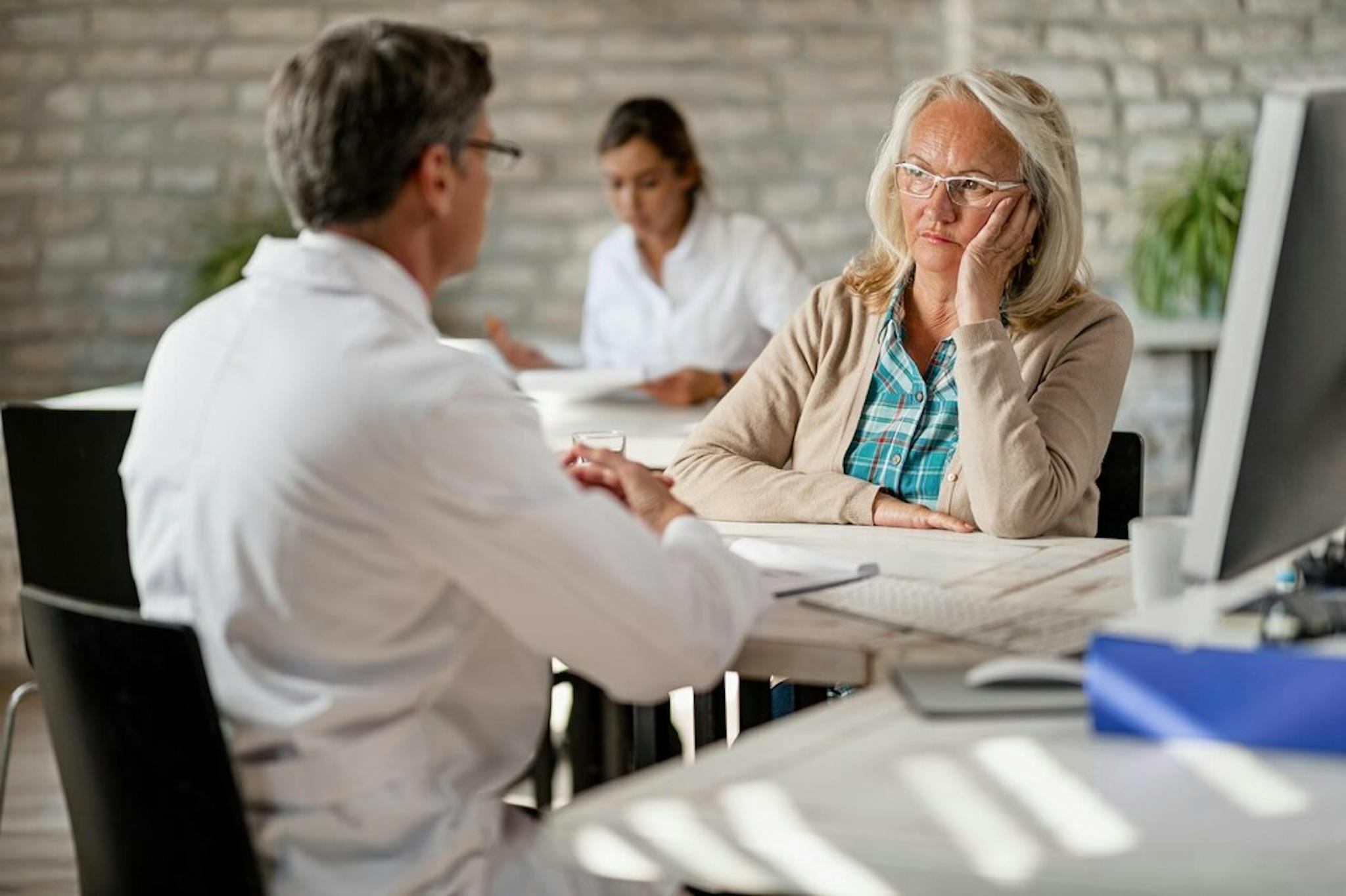 worried-mature-woman-talking-with-healthcare-worker