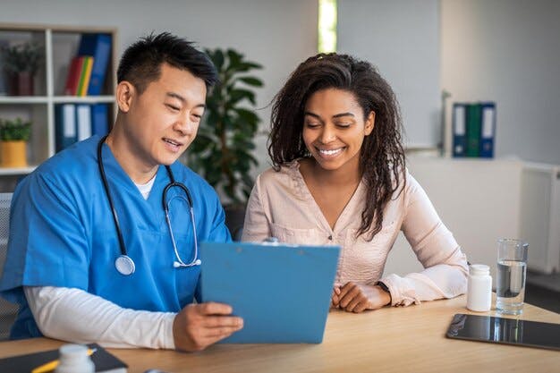 happy-senior-chinese-doctor-with-tablet-consulting-young-african-american-female-patient