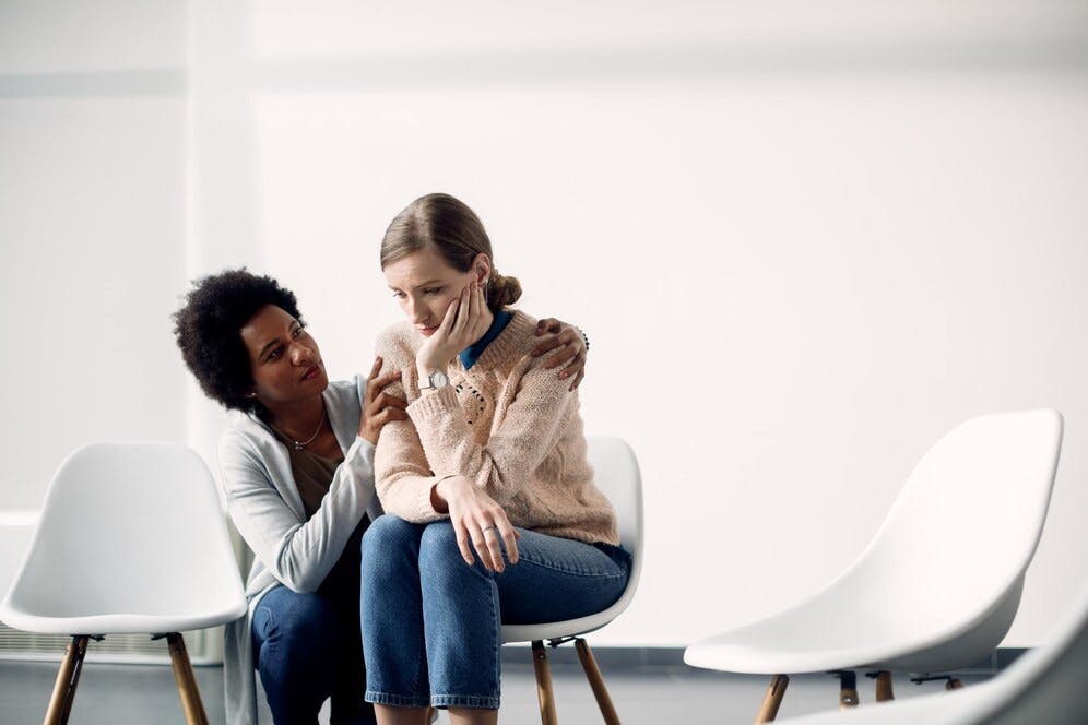 woman-consoling-sad-woman-before-therapy-meeting