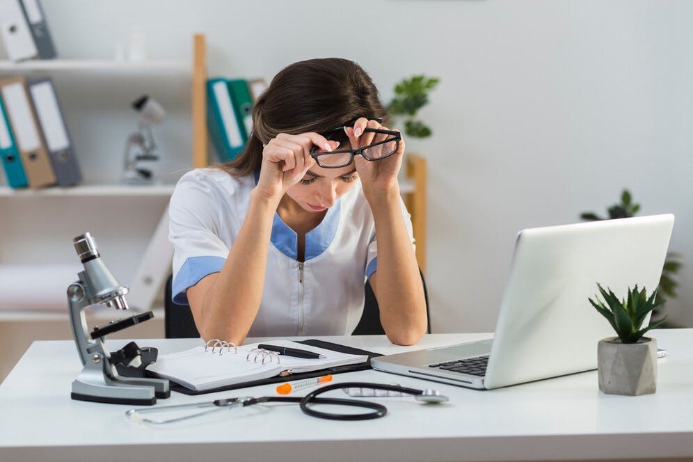 tired-female-doctor-taking-out-her-glasses