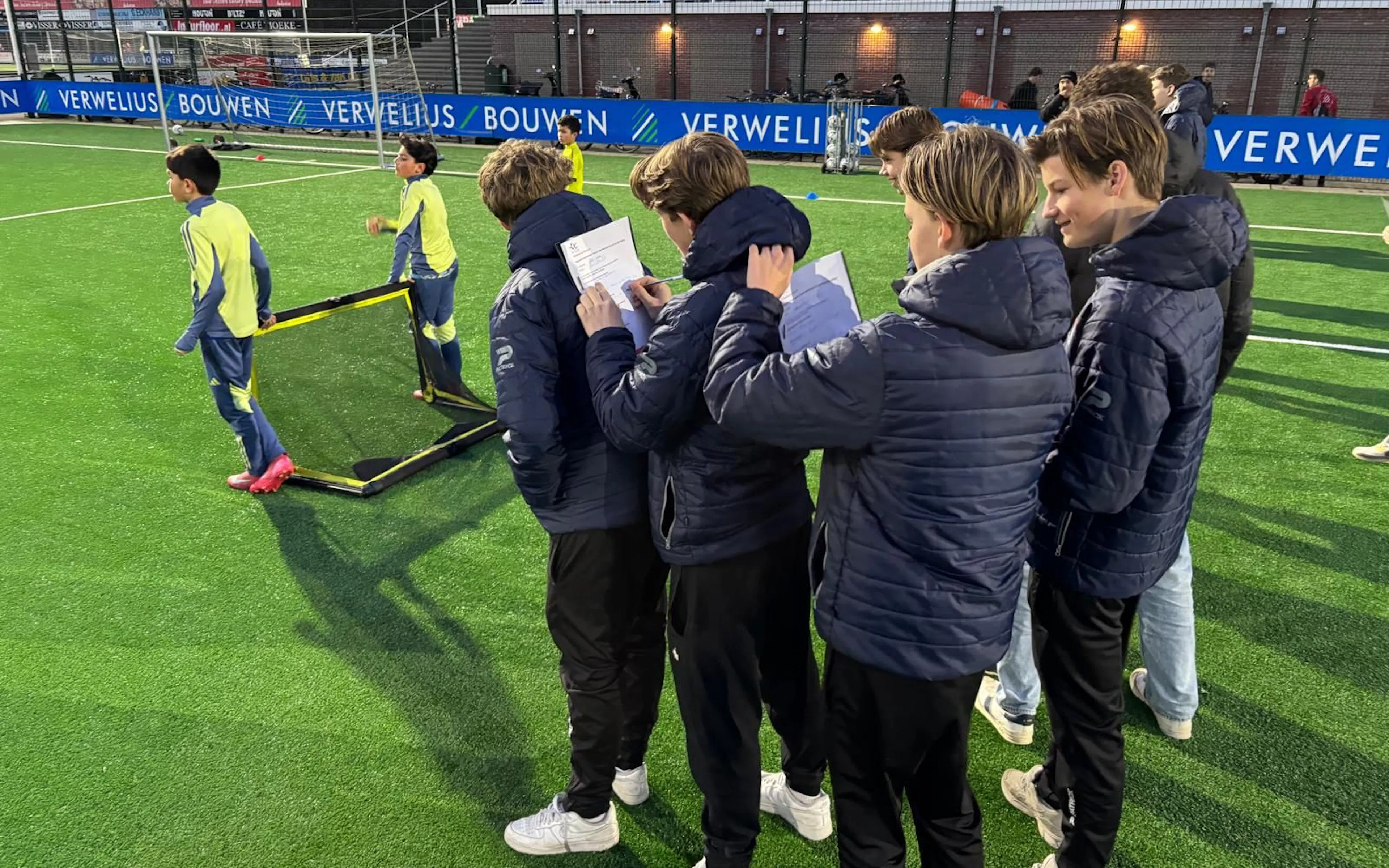 Jonge trainers die keurig notities maken